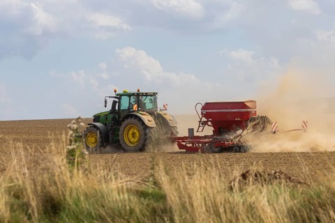 A tractor with a Horsch PRONTO DC 6 seed drill sowing in a dry field in late summer., Doma, Saxony,