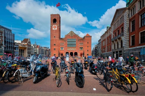Amsterdam, Netherlands, May 7, 2017: Beursplein with parked bicycles and motorcycles and Beurs van