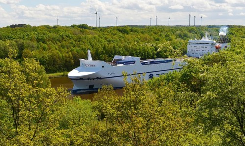 Car transporter, container ship in the forest on the Kiel Canal, Schleswig-Holstein, Germany,