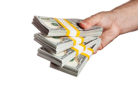 Creative business finance making money concept, hand holding stack of bundles of 100 US dollars