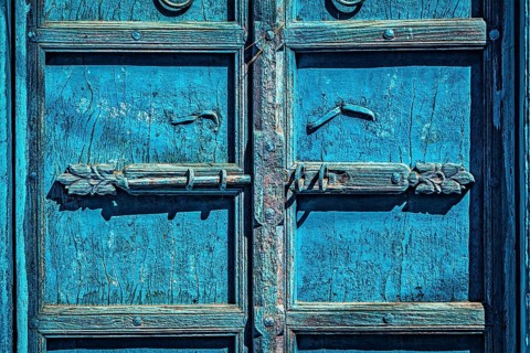 Latch with padlock on old textured door in India