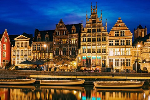 Old houses on Graslei street, canal and tourist boatds in the evening. Ghent, Belgium, Europe