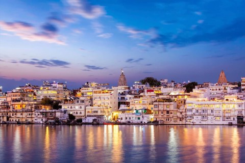 Evening view of illuminated houses on lake Pichola in twilight, Udaipur, Rajasthan, India, Asia
