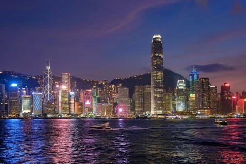 Hong Kong skyline cityscape downtown skyscrapers over Victoria Harbour in the evening illuminated