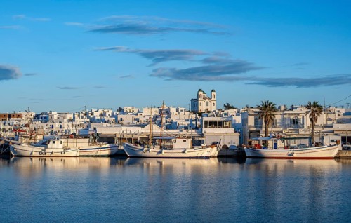 View of Naoussa, Fishing boats in the harbour at sunset, reflected in the sea, White Cycladic