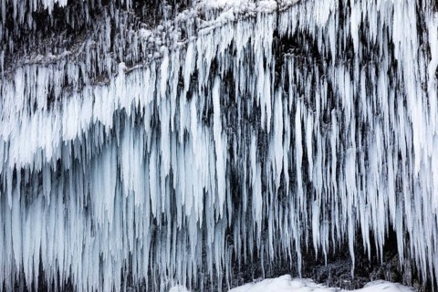 Icicles on the rock face at Skogafoss waterfall, Sudurland, Iceland, Europe