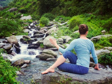 Yoga exercise outdoors, woman doing Ardha matsyendrasana asana, half spinal twist pose at tropical
