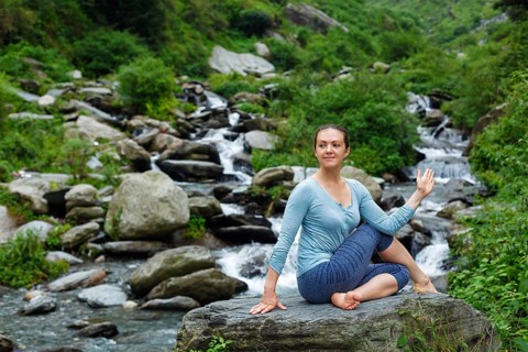 Yoga exercise outdoors, woman doing Ardha matsyendrasana asana, half spinal twist pose at tropical