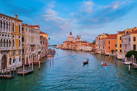 Panorama of Venice Grand Canal with boats and Santa Maria della Salute church on sunset from Ponte