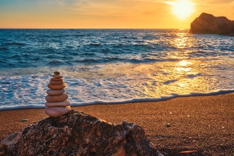 Concept of balance and harmony. Cairn stack of stones pebbles cairn on the beach coast of the sea