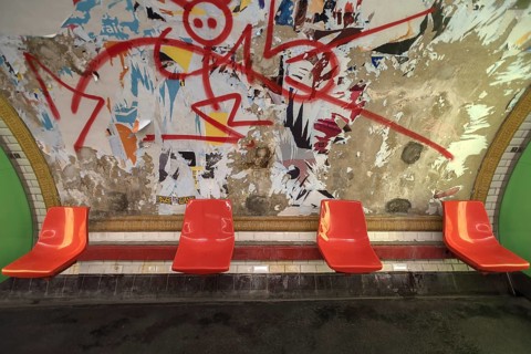 Red seats in the metro in front of a torn down billboard, Paris, France, run down, graffiti, Europe