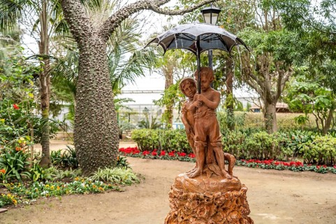 Fountain Fuente de los Niños del Paraguaswith two children under an umbrella in Parque Genovés,