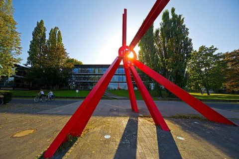 Bright red sculpture made of steel profiles L'Allumé by Mark di Suvero in front of the Bundeshaus