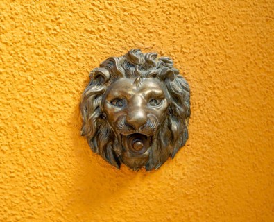 Doorbell knob in the shape of a lion on a yellow house wall, Burano Island, Venice, Veneto, Italy,