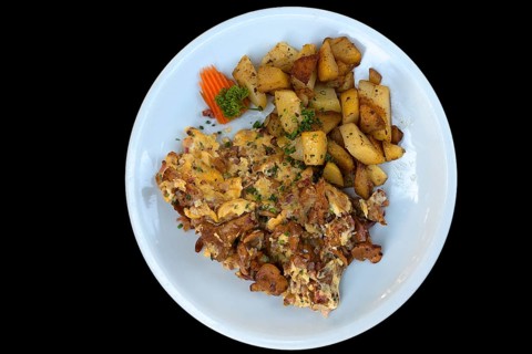 Fried potato with scrambled eggs on black background, Bavaria, Germany, Europe