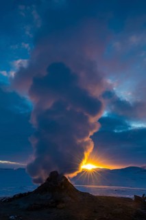 Mud pot with steam source at sunrise, Hverir solfataras field, fumaroles, snow-covered geothermal