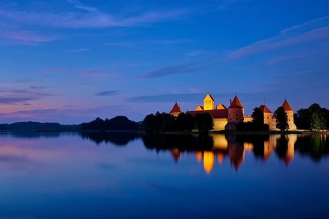 Evening view of Trakai Island Castle in lake Galve illuminated in the night reflecting in peaceful