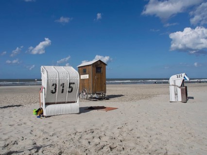 Beach chairs and a wooden hut stand side by side on the quiet beach, spiekeroog, east frisia, north