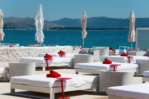 Sunny coastal landscape with white deckchairs and views of the calm blue sea, Amadria Park, En