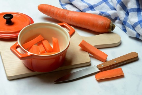 Carrot, carrot sticks in pot and kitchen knife