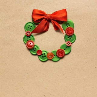 Creative concept photo of Christmas wreath made of buttons on a brown background