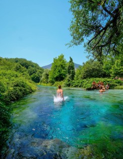 Muzina, Albania, tourists bathe in the Syri i Kaltër, THE BLUE EYE, is the country's most