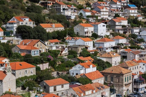 High angle view of tan and white trim houses and villas with traditional terracotta clay tile