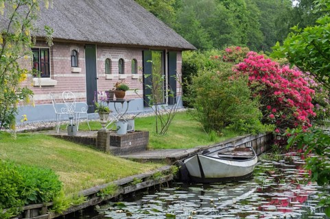 Cosy house on the canal with boat and flowering shrubs in an idyllic area, Giethoorn, municipality