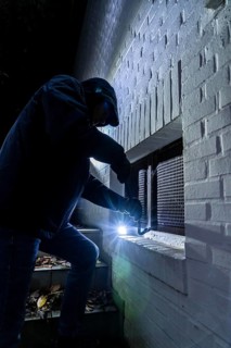 Symbolic image of a house burglary, perpetrator has approached a house from the garden side and