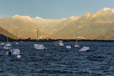 Boats lying in the water, Locarno, Lake Maggiore, surrounding mountains in the evening light,