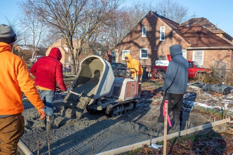 Detroit, Michigan - Workers pour and finish concrete for walking paths in Three Mile Park in