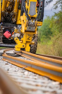Yellow construction machine working on a railway track on ballast, track construction, Hermann