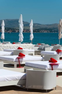 White deckchairs with red towels on the coast overlooking the sea, Amadria Park, En Vogue Beach