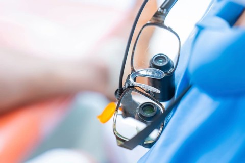 Close-up of medical magnifying glasses worn over a blue gown, dental practice, Germany, Europe