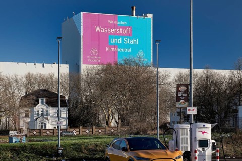 E-charging station and large poster for climate steel at the ThyssenKrupp Steel Europe plant,