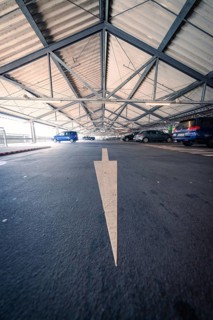 Car park with a painted arrow on the floor and parked cars, Kaufland Calw car park, Calw district,