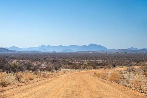 Gravel track leads through barren dry landscape with hills, Kaokoveld, Kunene, Namibia, Africa