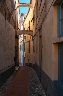 Picturesque narrow alley in the historic town centre with a view of the tower of the baroque church