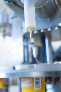 Close-up of a yoghurt filling process in a production plant, ice cream production Haselstaller Hof,