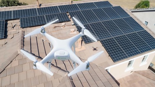 UAV drone inspecting solar panels on large house