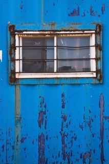 Blue painted metal building with window protected with steel bars, Quebec, Canada, North America