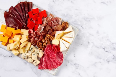 Assortment of cheese meat cuts, on a plate, top view, no people