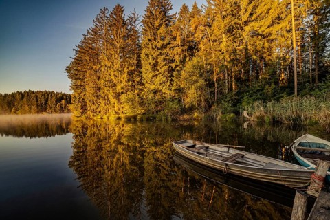 Boats in the autumnal Schmutter Weiher in the Allgäu near the municipalities of Halblech,