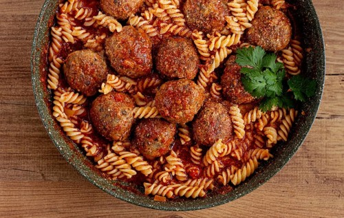 Minced meat meatballs, in tomato sauce, with fusilli pasta, in a cast-iron pan, homemade, no people