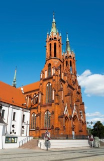 Red brick church with high, pointed towers and a clear sky, Church of the Blessed Virgin Mary,