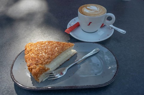 A slice of bee sting and a cup of cappuccino, on a bistro table, Bavaria, Germany, Europe