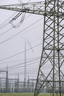 Wind farm in the fog, high-voltage pylons, dark doldrums, no wind no direct sunlight, in the