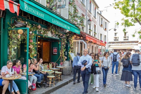 Lively street scene in front of a restaurant in Montmartre, Paris with many people, Paris