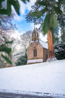 Small church in the snow, surrounded by wintry trees and a clear sky, spa garden, English Church,
