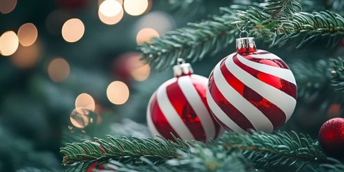 Christmas banner with bauble ornaments with red and white stripes on tree with copy space.